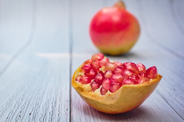 Frische Frucht des Granatapfels auf hölzernem Weiß.