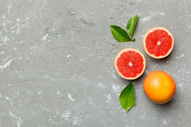 Frische Frucht-Grapefruit mit saftigen Grapefruitscheiben auf farbigem Hintergrund Draufsicht Copy Space kreatives Sommerkonzept Die Hälfte der Zitrusfrüchte in minimaler Wohnung lag mit Kopierraum