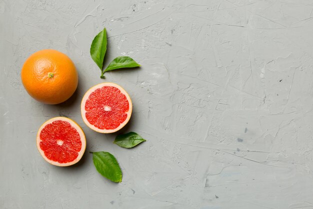 Frische Frucht-Grapefruit mit saftigen Grapefruitscheiben auf farbigem Hintergrund Draufsicht Copy Space kreatives Sommerkonzept Die Hälfte der Zitrusfrüchte in minimaler Wohnung lag mit Kopierraum