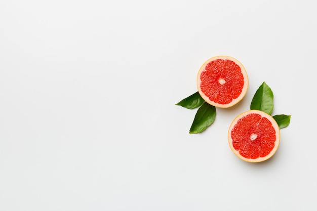 Frische Frucht-Grapefruit mit saftigen Grapefruitscheiben auf farbigem Hintergrund Draufsicht Copy Space kreatives Sommerkonzept Die Hälfte der Zitrusfrüchte in minimaler Wohnung lag mit Kopierraum