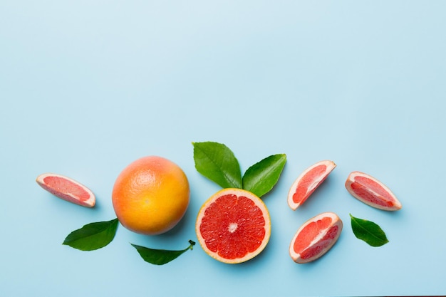 Frische Frucht-Grapefruit mit saftigen Grapefruitscheiben auf farbigem Hintergrund Draufsicht Copy Space kreatives Sommerkonzept Die Hälfte der Zitrusfrüchte in minimaler Wohnung lag mit Kopierraum