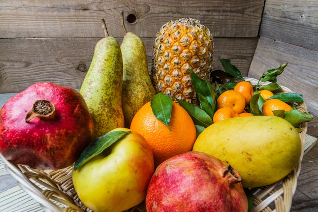 Frische Frucht in einem Korb auf Holztisch.