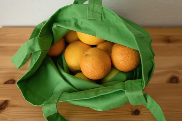 Foto frische fruchtorangen befinden sich im wiederverwendbaren beutel. umweltfreundliches produkt. sorge für die umwelt