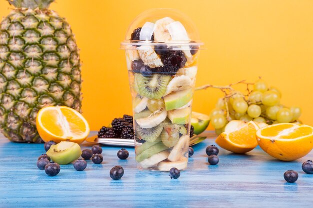 Frische Früchte auf einer Tasse mit exotischen Früchten auf Holztisch. Tropisches saftiges gesundes Obstsortiment Dessert.