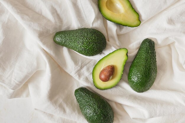 Frische ganze und geschnittene Avocadofrucht auf hellem Hintergrund