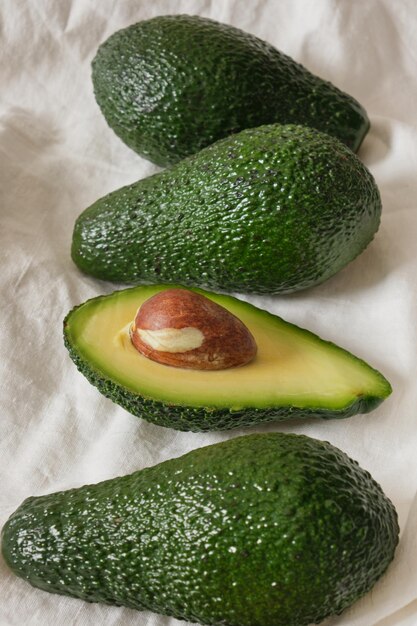 Frische ganze und geschnittene Avocadofrucht auf hellem Hintergrund