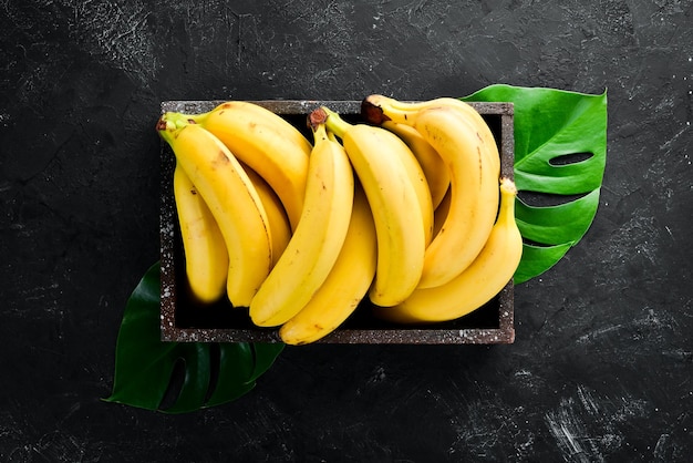 Foto frische gelbe bananen auf einem schwarzen steintisch draufsicht freier kopierplatz