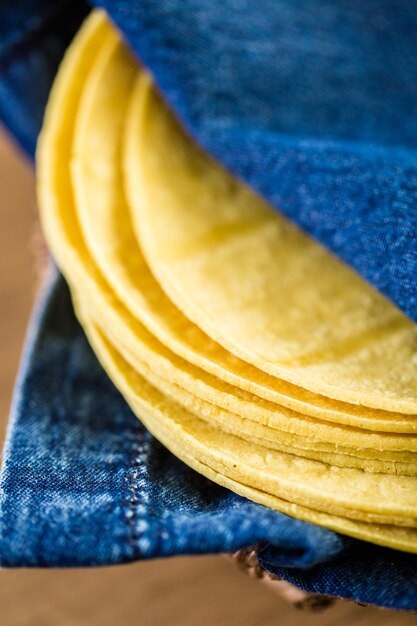 Frische gelbe Maistortillas auf einem hölzernen Hintergrund.