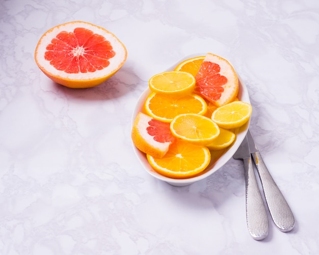 Frische gemischte Früchte Gesunde Ernährung, gesunde Ernährung von Zitrus-Orangen, Zitronen und Grapefruit auf weißem Hintergrund und Teller