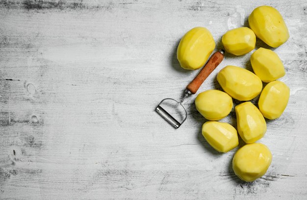 Foto frische, geschälte kartoffeln auf einem weißen tisch