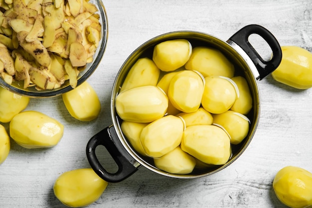 Foto frische, geschälte kartoffeln auf einem weißen tisch