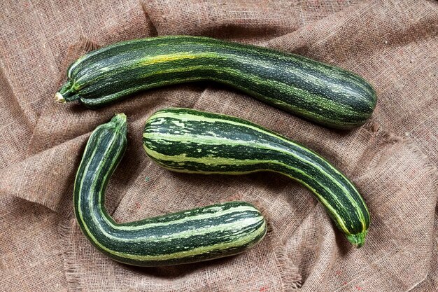 Frische gestreifte Zucchini auf Sackleinen