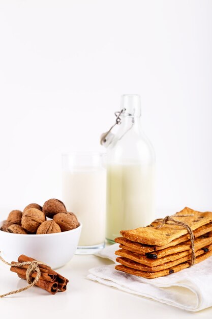 Frische gesunde Milchplätzchen mit Rosinen-Walnuss-Zimtstangen auf selektivem Fokus des weißen Hintergrundes Beschneidungspfad eingeschlossen