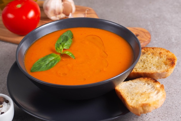 Frische gesunde Tomatensuppe mit Basilikum-Pfeffer-Knoblauch-Tomaten und Brot auf Holzhintergrund Spanische Gazpacho-Suppe Linsen- und Kürbissuppe