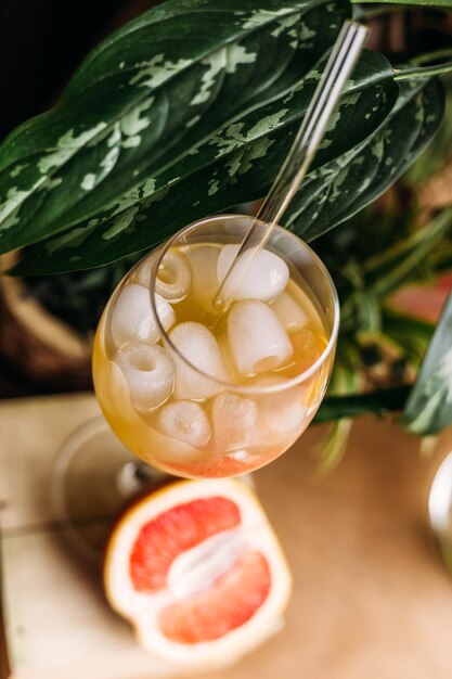 Frische Grapefruits und ein Glas Grapefruitcocktail