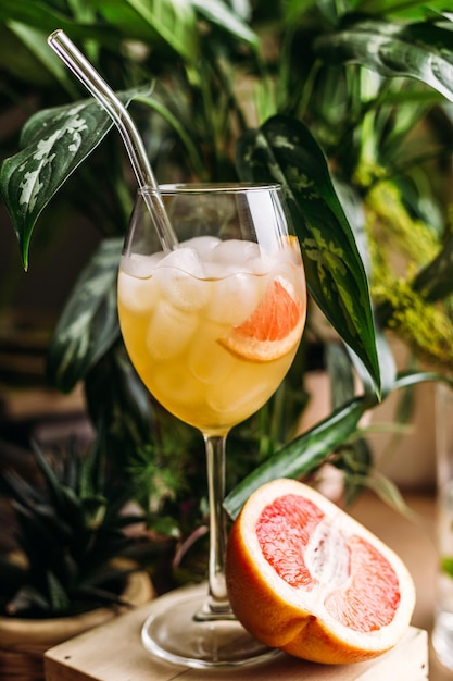 Frische Grapefruits und ein Glas Grapefruitcocktail