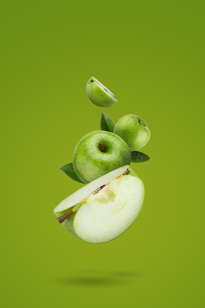 Frische grüne Äpfel und grüne Apfelscheiben auf grünem Hintergrund