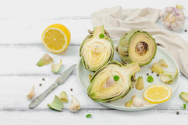 Frische grüne Artischocken kochen auf hölzernem Hintergrund Traditionell