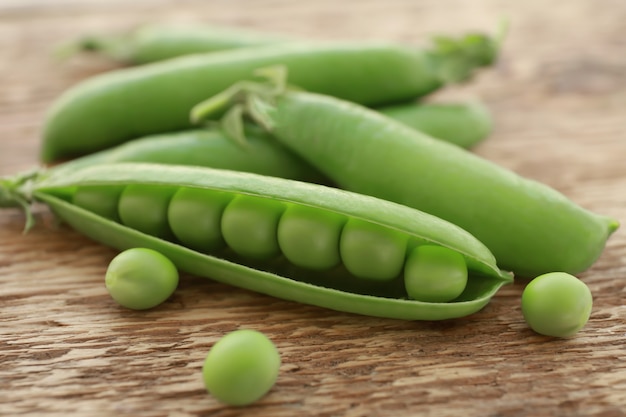 Frische grüne Erbsen auf Holztisch