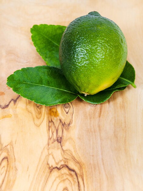 Frische grüne Kaffirlimettenfrucht mit Blättern an Bord