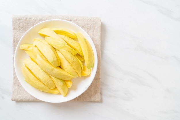 Frische grüne und goldene Mango auf Teller geschnitten