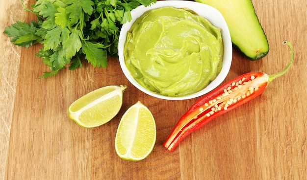 Frische Guacamole in Schüssel auf Holztisch