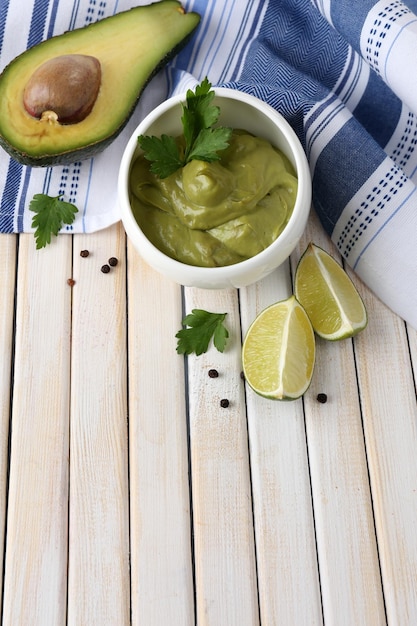 Frische Guacamole in Schüssel auf Holztisch