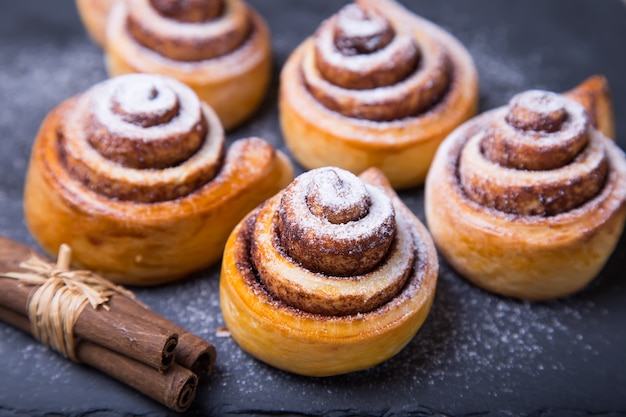 Frische hausgemachte Brötchen mit Zimt, Zimtstangen.