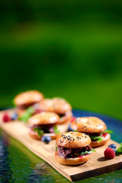 Frische hausgemachte Burger mit Speck, Basilikum, Tomaten und Beeren