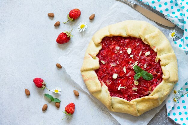 frische hausgemachte Erdbeeren Galette mit Nusscreme auf grauem Stein- oder Schieferhintergrund