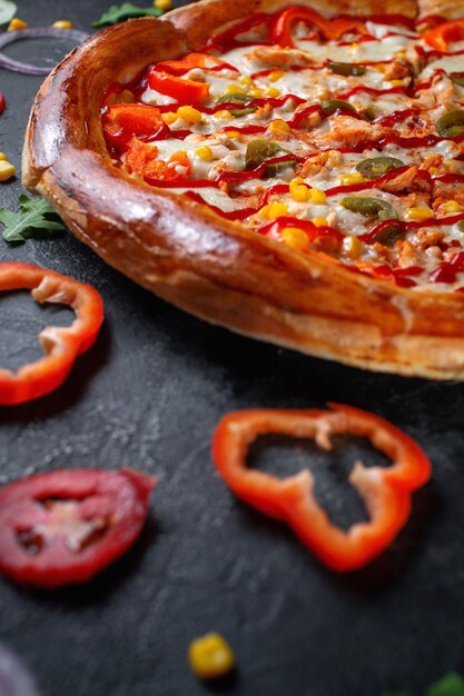 Frische hausgemachte italienische Pizza Margherita mit Oliven und roten bulgarischen Paprika auf dunklem Hintergrund