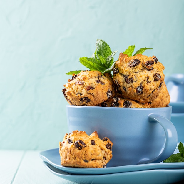 Frische hausgemachte leckere Rosinenmuffins in blauer Tasse, zuckerfrei. Gesundes Lebensmittelkonzept mit Kopierraum