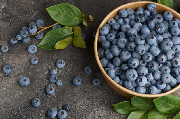 Frische Heidelbeeren mit Wassertropfen in einer Holzschale Blick von oben Das Konzept der gesunden und diätetischen Ernährung