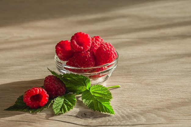 Frische Himbeeren in einem Glasschüssel-Kopienraum