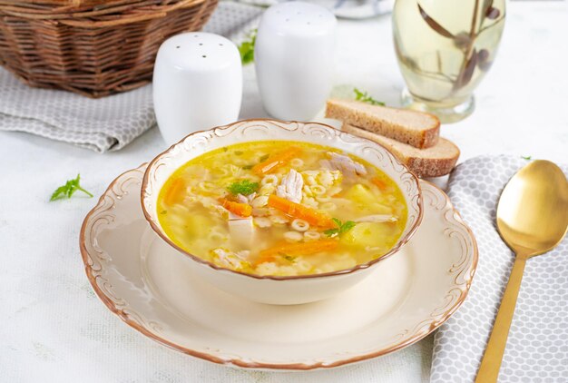 Frische Hühnersuppe mit Gemüse und Stellinennudeln in einer Schüssel mit Karotten und Petersilie