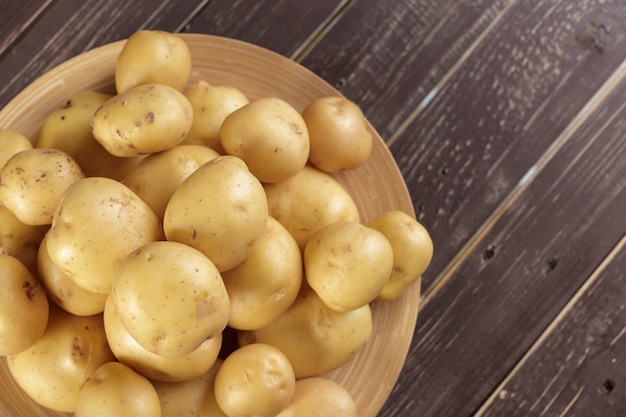 Frische Kartoffeln auf dem hölzernen Hintergrund