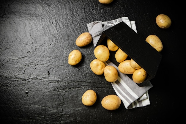 Frische Kartoffeln auf schwarzem Hintergrund