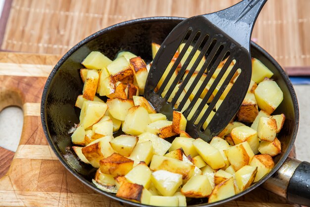 Frische Kartoffeln brieten in einer Wanne mit Öl und Rührstababschluß oben