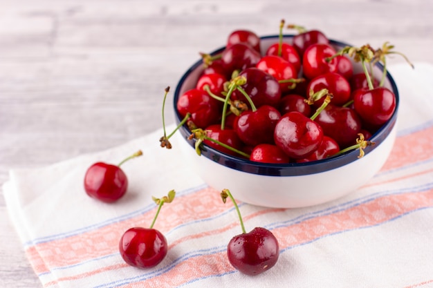 Frische Kirsche auf weißem Holztisch. Reife süße Beeren in Wassertropfen