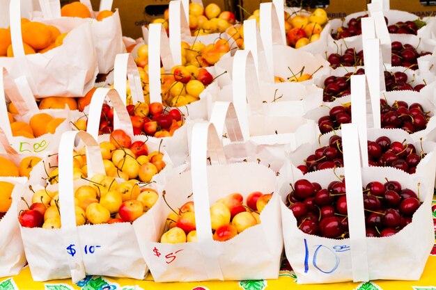 Frische Kirschen in weißen Papiertüten auf dem lokalen Bauernmarkt.