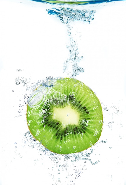 Frische Kiwi, die in Wasser fällt