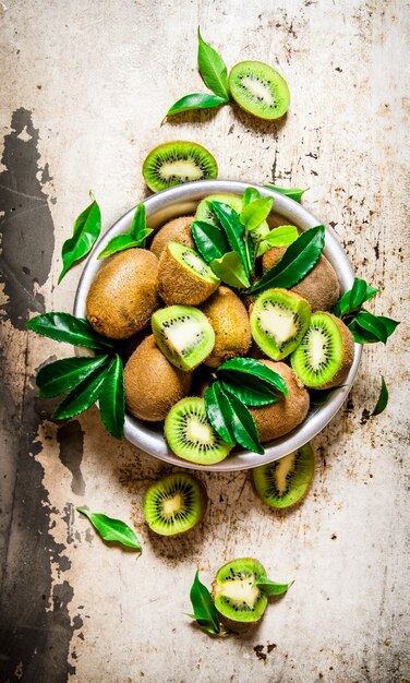 Frische Kiwis in einer Tasse mit Blättern