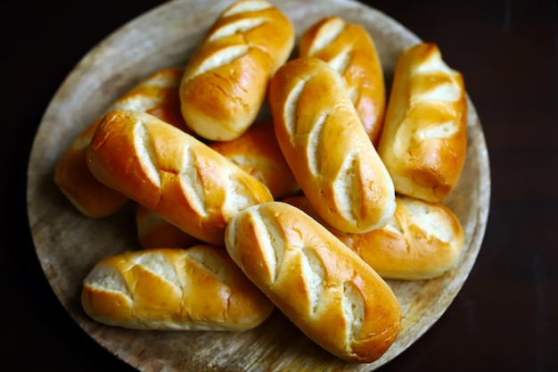 Frische kleine Brötchen auf einem Holztablett