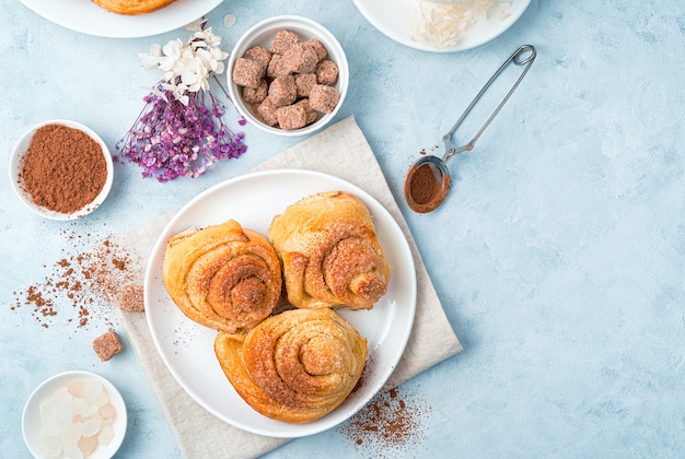 Frische, knusprige Brötchen mit Kakao auf hellblauem Hintergrund.