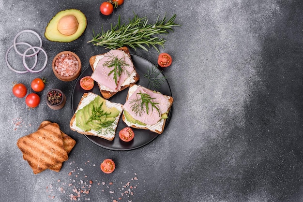 Frische, köstliche Schinkenbutter-Avocado- und Sesam-Sandwiches auf einem Holzschneidebrett