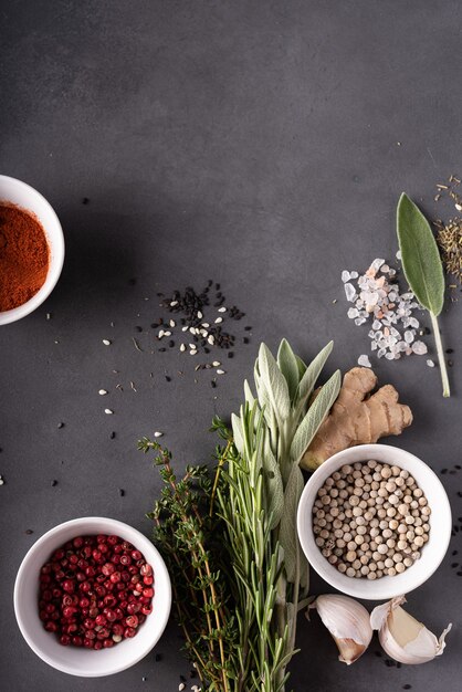 Frische Kräuter zum Kochen mit getrockneten Gewürzen auf einem grauen Tisch