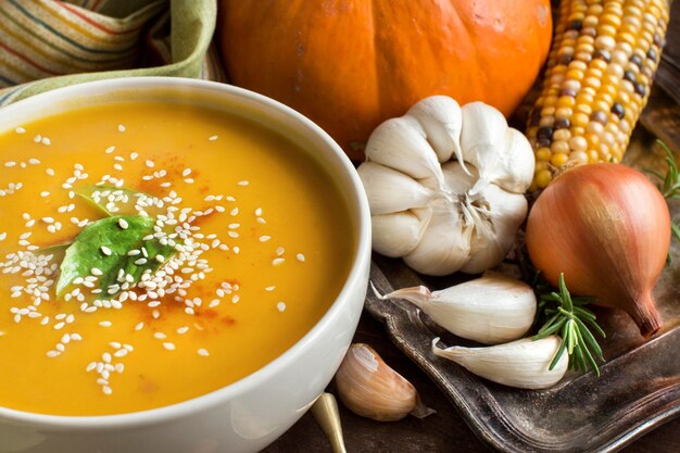 Frische Kürbissuppe mit einem Löffel und Gemüse schließen