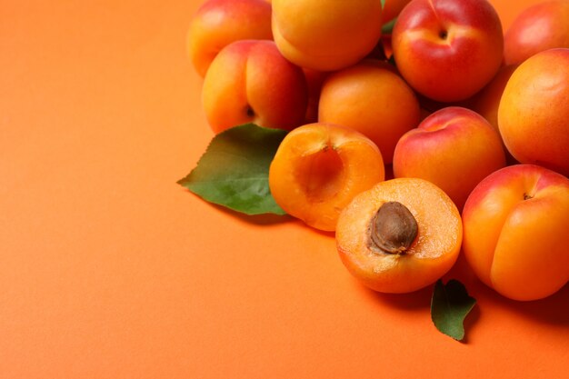 Frische leckere Aprikosen auf orangefarbenem Hintergrund