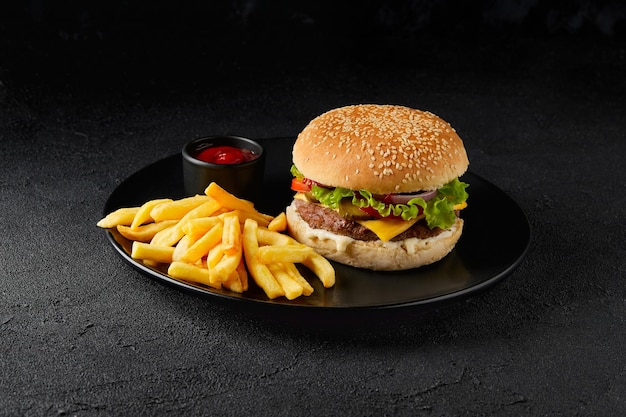 Frische leckere Burger Pommes Frites und Ketchup auf dunklem Hintergrund