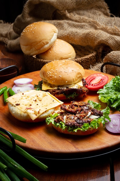 Frische, leckere Rindfleisch-Burger, serviert auf einem Holztablett auf dem Tisch im Fast-Food-Shop